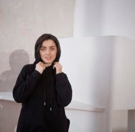 medium-shot-smiley-woman-posing-with-hoodie